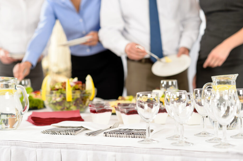 Business catering people serving themselves buffet at company meeting